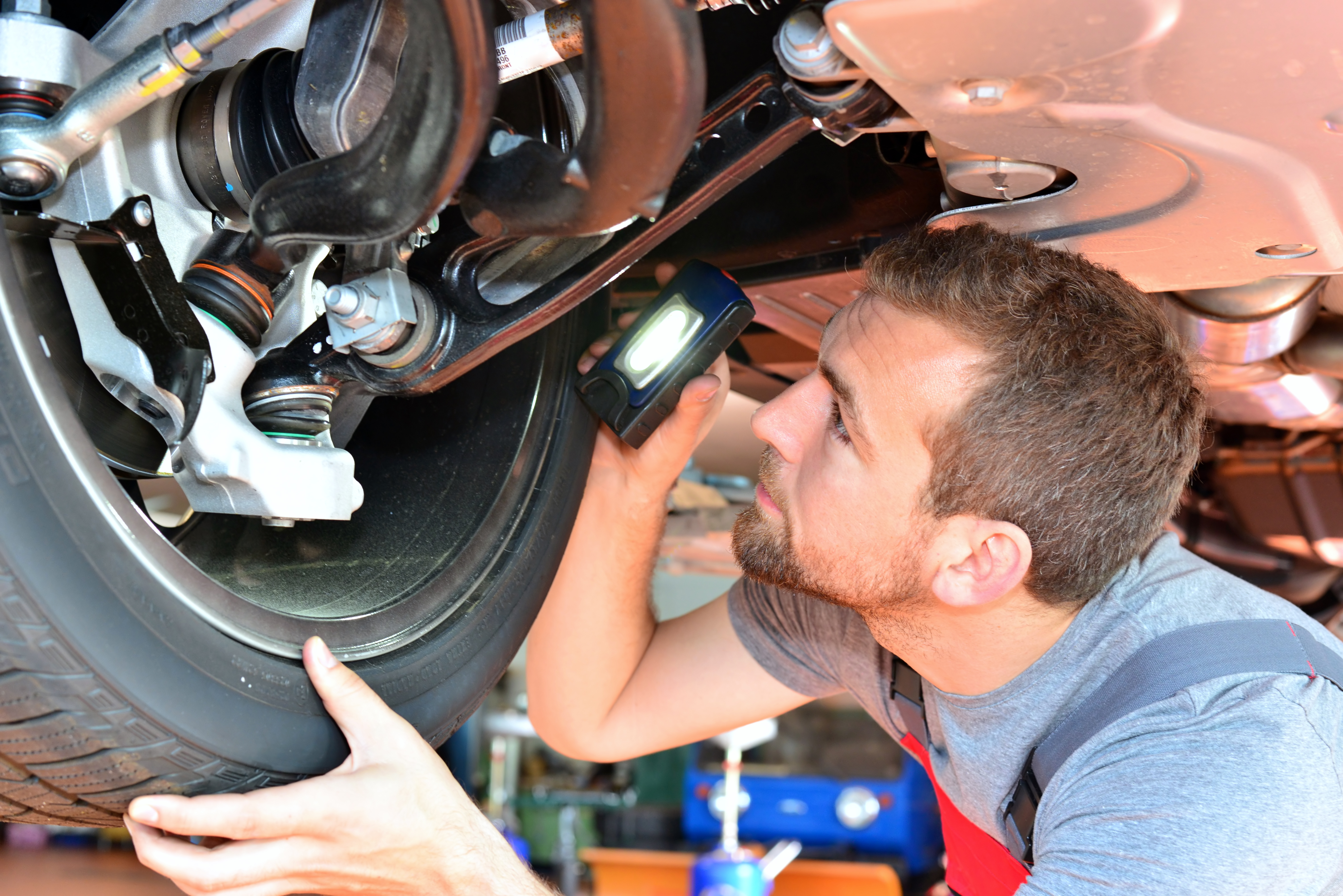 Mechanic inspecting vehicle brakes at IN'n'OUT Autocentres